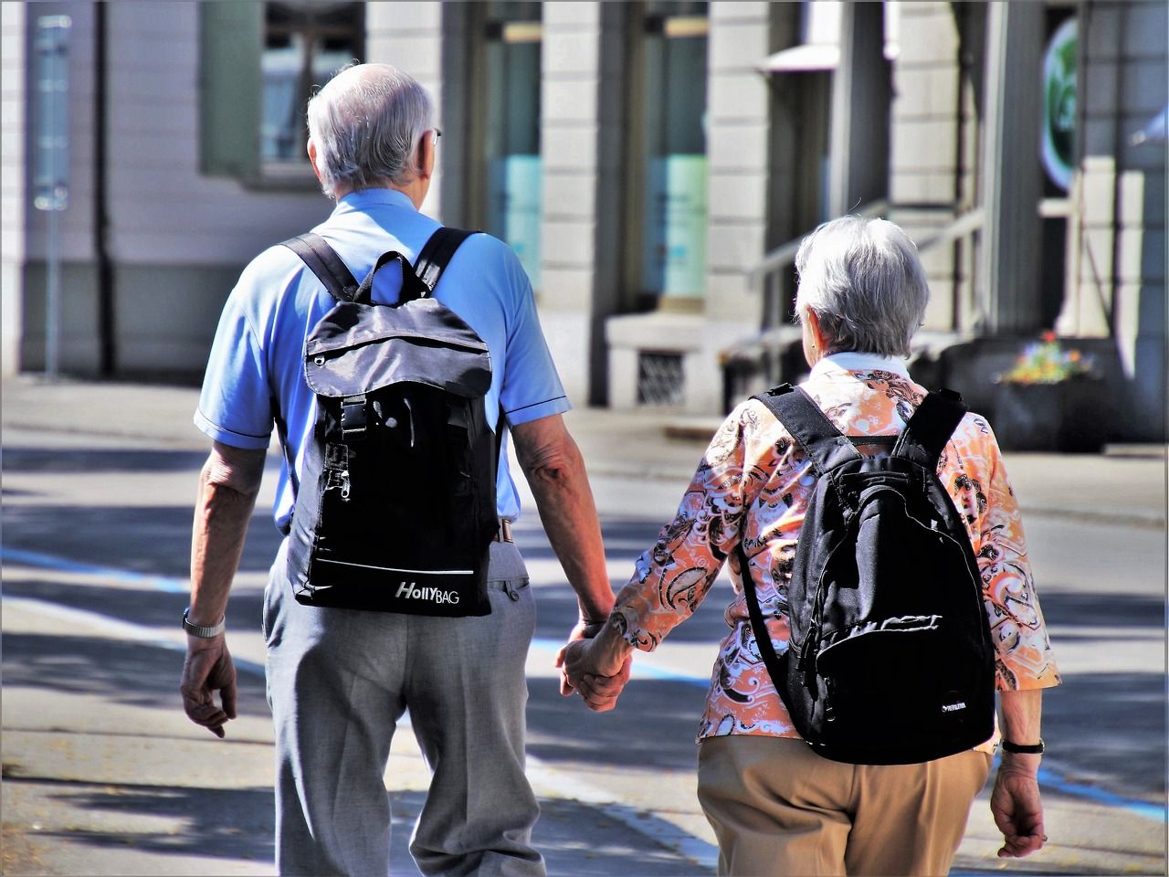 Ein älteres Paar hält Händchen und läuft durch die Stadt. senior couple